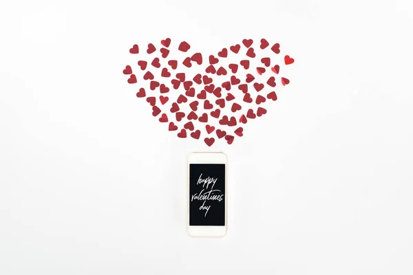 Flat lay with red heart symbols and smartphone with 