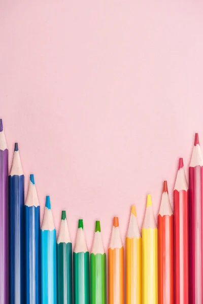 Vista superior de los lápices multicolores arco iris sobre fondo rosa, concepto lgbt - foto de stock