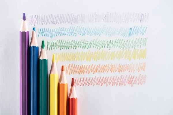 Top view of rainbow multicolored pencils and strokes on grey background, lgbt concept — Stock Photo