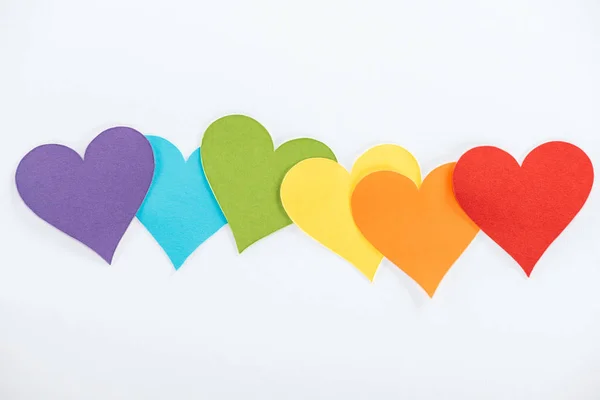 Corazones de papel de color arco iris sobre fondo gris, concepto lgbt — Stock Photo