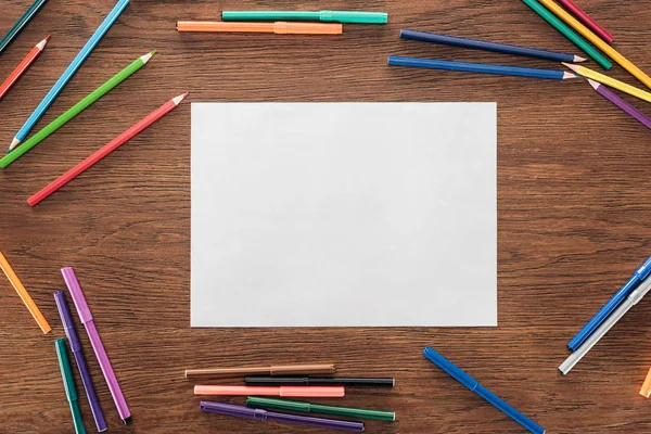 Пустая бумага с цветными карандашами и войлочными ручками на деревянной коричневой поверхности, концепция lgbt — стоковое фото