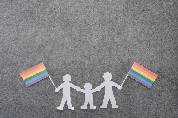 Белая бумага вырезать однополые семьи с радужными флагами на сером фоне, lgbt концепции — стоковое фото