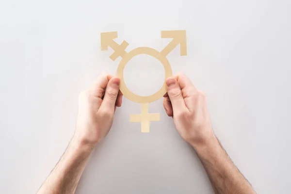 Частичный взгляд человека с белым бумажным гендерным знаком на сером фоне, концепция lgbt — стоковое фото
