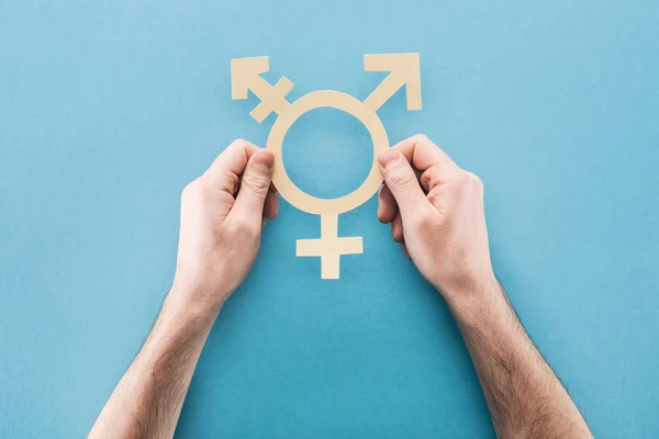 Partial view of man holding white paper gender sign on blue background, lgbt concept — Stock Photo