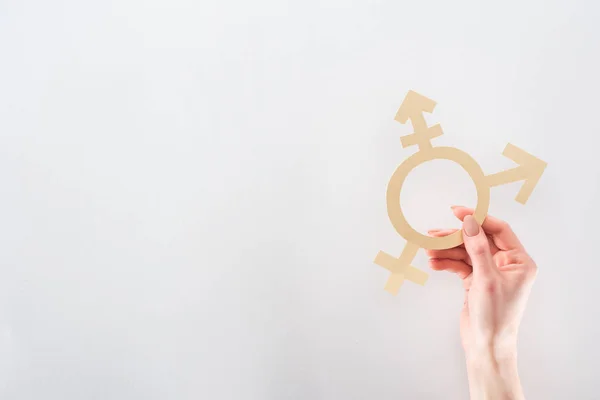 Partial view of female hand with paper cut gender sign on grey background, lgbt concept — Stock Photo