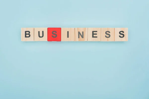 Top view of business lettering arranged of wooden cubes on blue background — Stock Photo