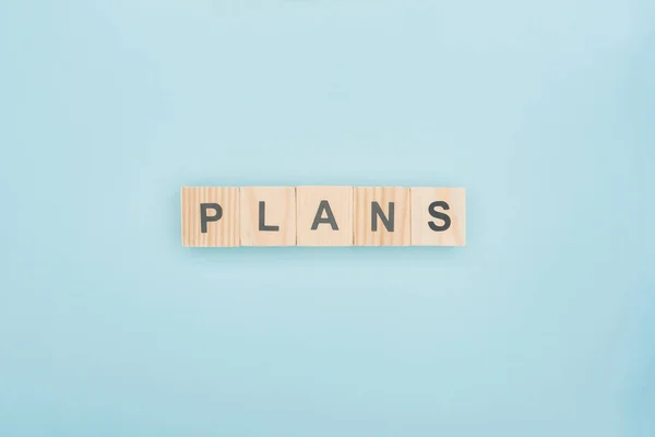 Top view of plans lettering made of wooden blocks on blue background — Stock Photo