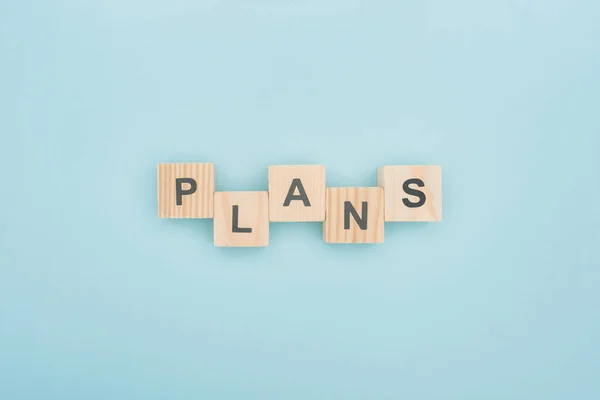 Top view of plans lettering arranged of wooden cubes on blue background — Stock Photo