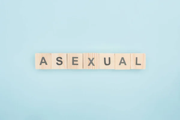 Vista superior de letras asexuales hechas de cubos de madera sobre fondo azul - foto de stock