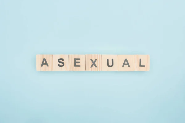Top view of asexual lettering made of wooden cubes on blue background — Stock Photo