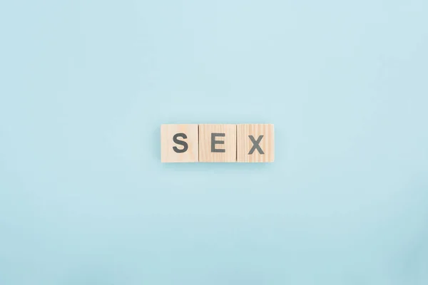 Top view of sex lettering made of wooden cubes on blue background — Stock Photo