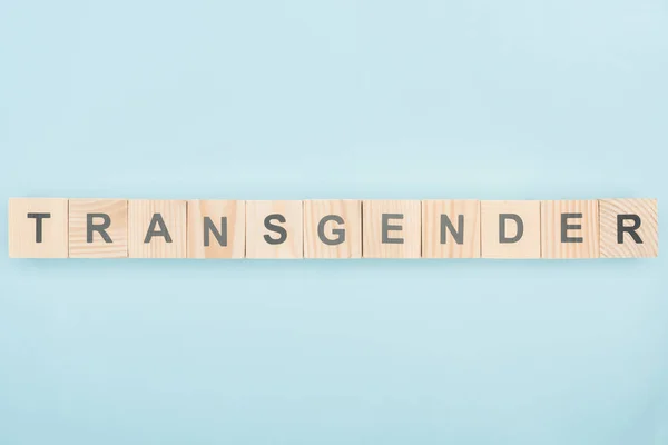 Draufsicht auf Transgender-Schriftzug aus Holzwürfeln auf blauem Hintergrund — Stockfoto
