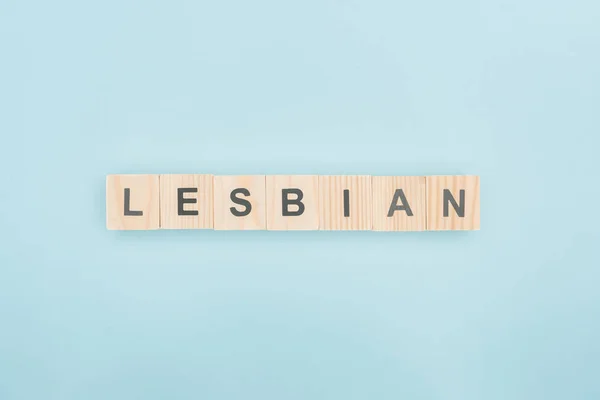 Vista superior de letras lésbicas feitas de cubos de madeira no fundo azul — Fotografia de Stock