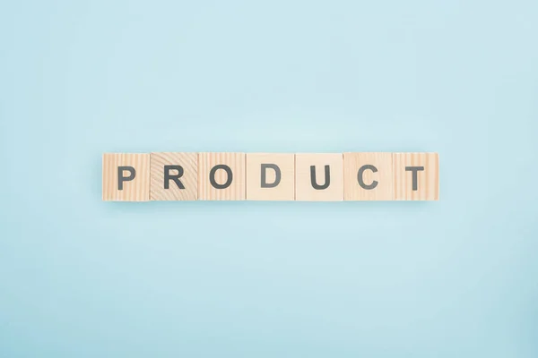 Top view of product lettering made of wooden cubes on blue background — Stock Photo