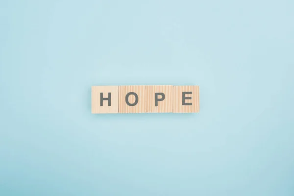 Top view of hope lettering made of wooden cubes on blue background — Stock Photo