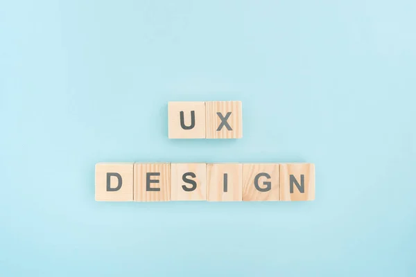 Vista superior de letras de design ux feitas de cubos de madeira no fundo azul — Fotografia de Stock
