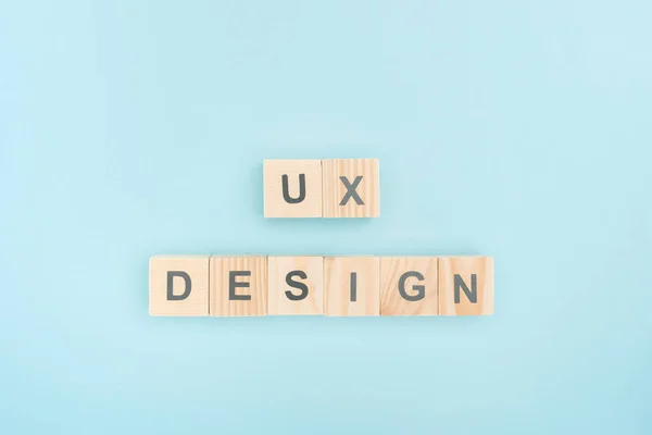 Vue du dessus du lettrage ux design en cubes de bois sur fond bleu — Photo de stock