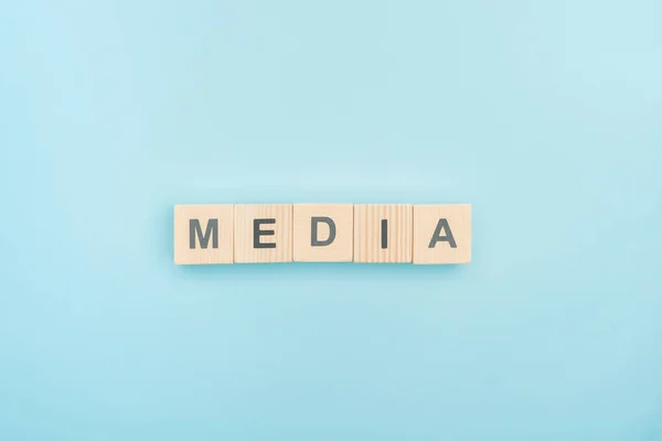 Draufsicht auf Medienschriftzug aus Holzwürfeln auf blauem Hintergrund — Stockfoto