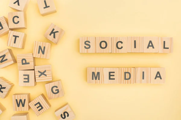 Vista superior de letras de mídia social com cubos de madeira no fundo amarelo — Fotografia de Stock