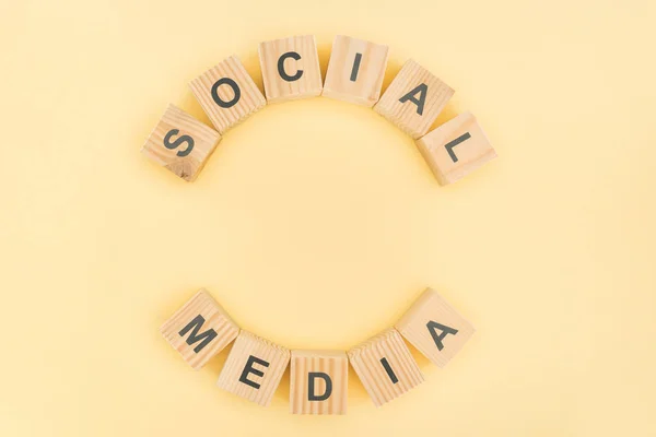 Top view of social media phrase made of wooden blocks on yellow background — Stock Photo