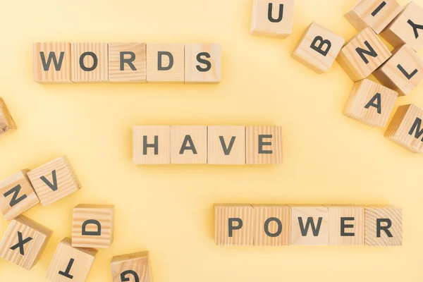 Top view of phrase words have power lettering with wooden cubes on yellow background — Stock Photo