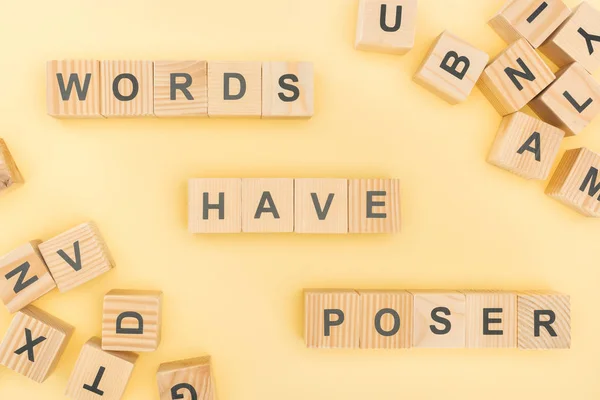 Top view of words have poser lettering with wooden cubes on yellow background — Stock Photo