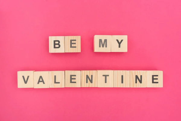 Top view of be my valentine lettering made of wooden cubes on pink background — Stock Photo