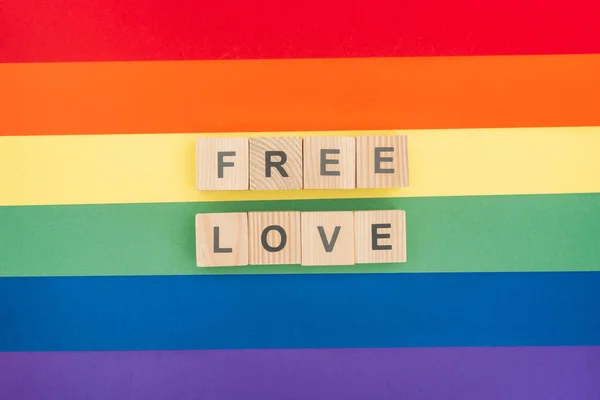 Vista dall'alto del lettering amore libero fatto di blocchi di legno su sfondo arcobaleno di carta — Foto stock