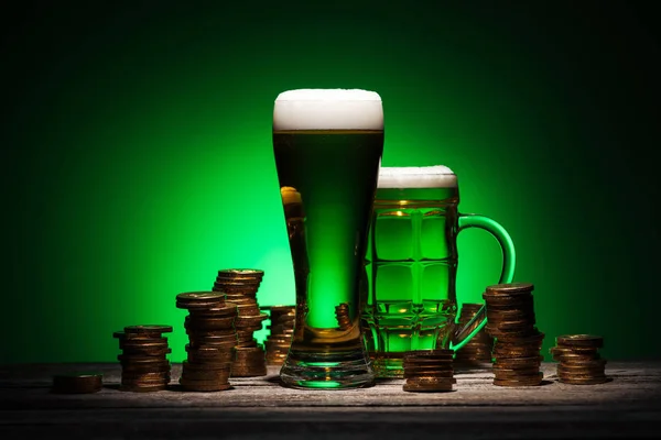 Bicchieri di birra irlandese in piedi su un tavolo di legno su sfondo verde — Foto stock