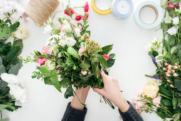 Vue recadrée des mains féminines bouquet de fleurs sur fond blanc — Photo de stock