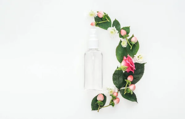 Вид зверху композиції з листям, квітами і порожньою пляшкою розпилення ізольовані на білому — стокове фото