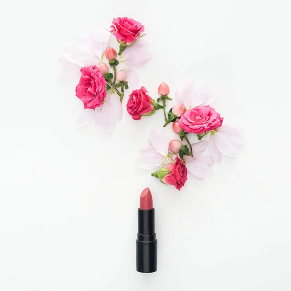 Vista superior de la composición con brotes de rosas, bayas, pétalos y lápiz labial aislados en blanco - foto de stock