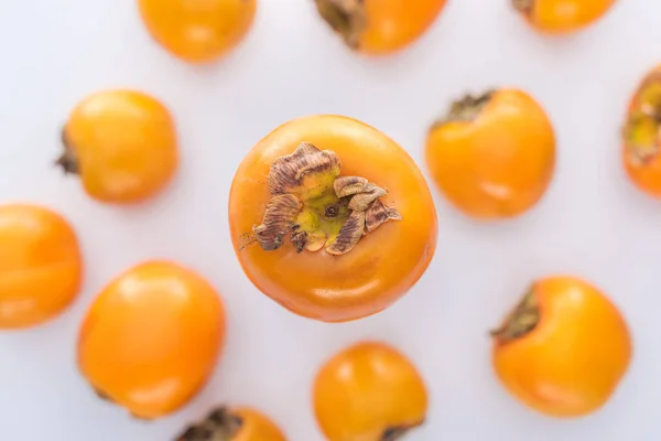 Selective focus of sweet and whole persimmons on white background — Stock Photo