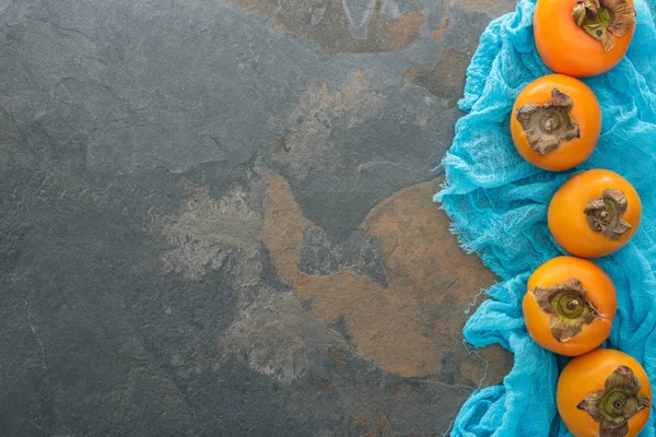 Vista dall'alto di cachi interi su stoffa blu con spazio di copia — Foto stock