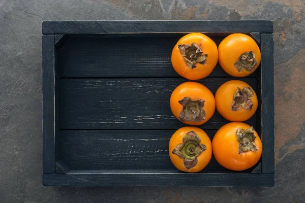 Ansicht ganzer Persimmons in Black Box mit Kopierraum — Stockfoto