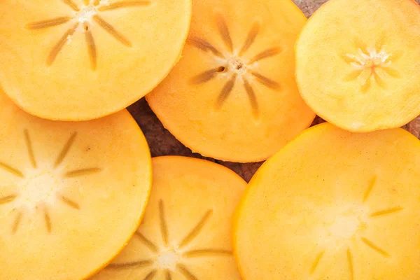 Primer plano de sabrosas rodajas de caquis maduros y naranjas - foto de stock