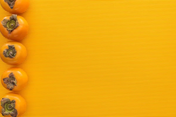 Вид зверху помаранчевих осіб на жовтому тлі з пробілом для копіювання — стокове фото