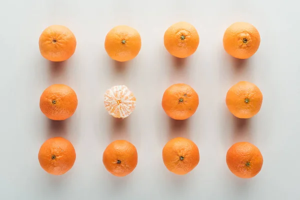 Flat lay with bright ripe orange tangerines with peeled one — Stock Photo