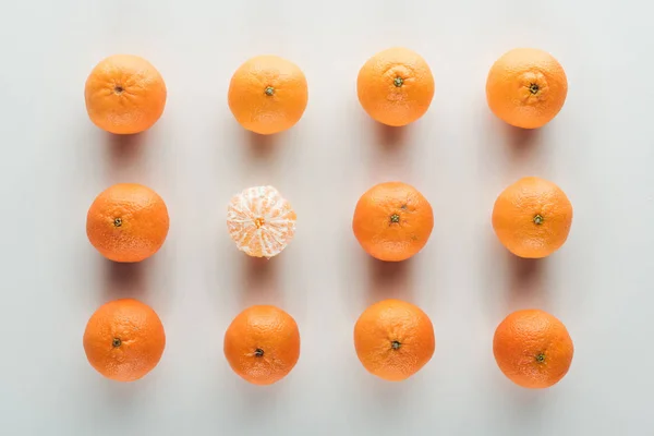 Tendido plano con mandarinas anaranjadas maduras brillantes con una pelada - foto de stock