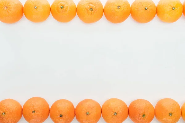 Rahmen aus reifen orangefarbenen Mandarinen auf weißem Hintergrund mit Kopierraum — Stockfoto