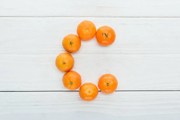 Top view of letter C made of fresh tangerines on wooden white background — Stock Photo