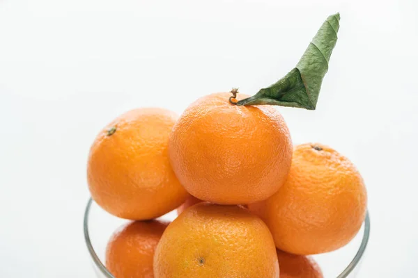 Gros plan de mandarines pile dans un bol en verre sur fond blanc — Photo de stock