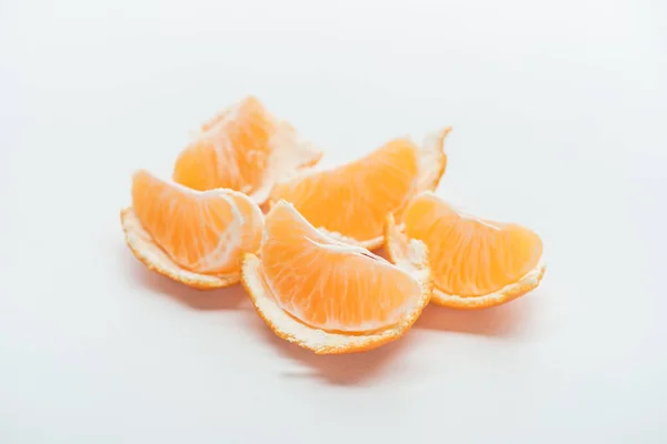Ripe tangerine slices with peel on white background — Stock Photo