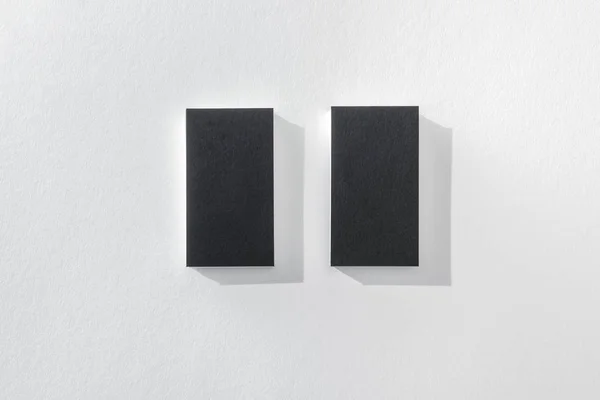 Vista superior de cartões pretos vazios no fundo branco com espaço de cópia — Fotografia de Stock