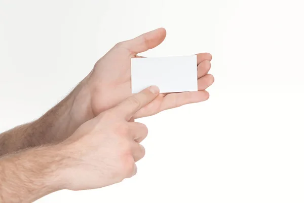 Vista recortada del hombre sosteniendo la tarjeta en blanco y vacío aislado en blanco - foto de stock
