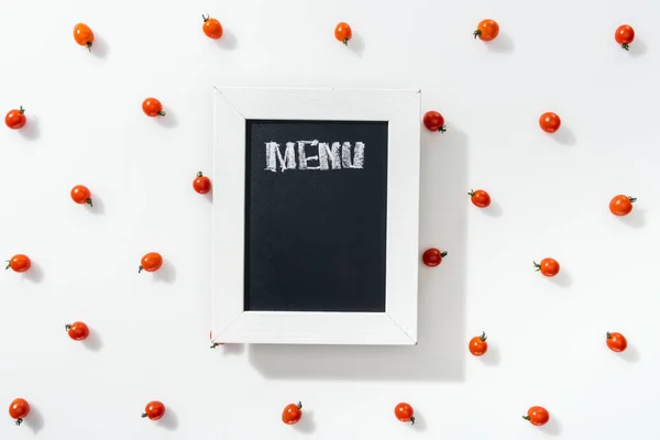 Vista dall'alto del pannello di gesso con scritte di menu tra pomodorini ciliegini — Foto stock