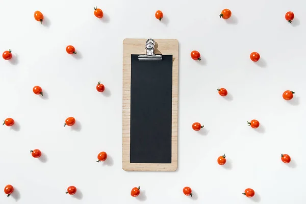 Top view of empty clipboard with cherry tomatoes on white background — Stock Photo