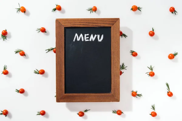 Placa de giz com letras de menu entre tomates cereja e folhas — Fotografia de Stock