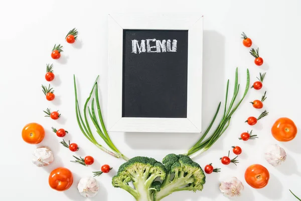 Pizarra con letras de menú entre tomates, brócoli, cebolla y ajo - foto de stock