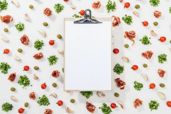 Vista superior da área de transferência vazia entre prosciutto, azeitonas, dentes de alho, vegetação e tomates cereja — Fotografia de Stock